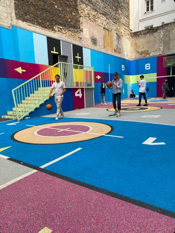 People playing on a colorful basketball court