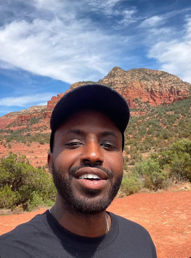 A portrait on a trail beneath red rock cliffs